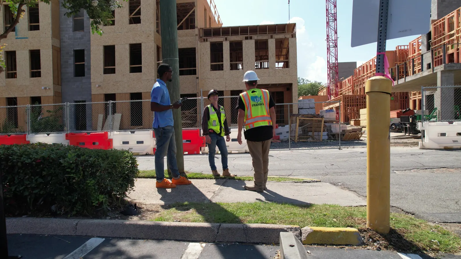 Denzel speaking with contractors on site — Under One Sun aerial imagery