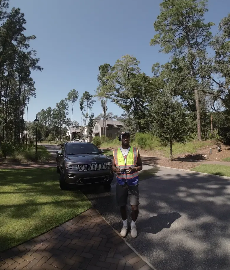 Denzel in flight vest and FPV goggles — Under One Sun aerial imagery