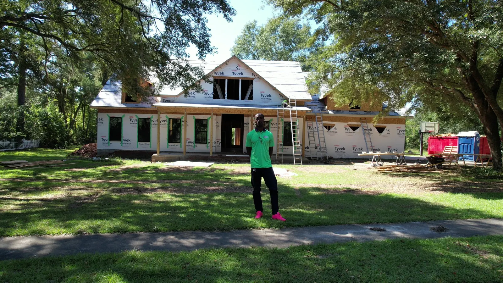 Black Residence framed and Tyvek wrapped, Denzel in front — Under One Sun residential design