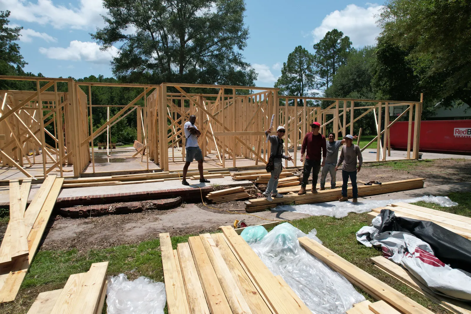 Black Residence partially framed with Denzel and workers in front — Under One Sun residential design